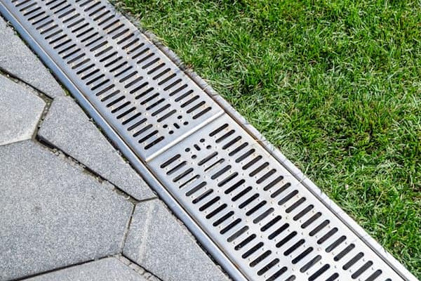 Stormwater drainage on city streets, street separation stormwater drainage, for drainage and separation of water from lawn and pavement. Drainage system for meltwater, rainwater flows and floods